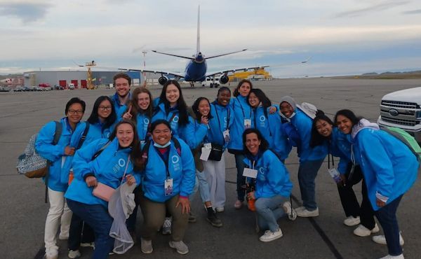 Des bénévoles habillés en bleu prennent la pose sur le tarmac de l'aéroport d'Iqaluit.
