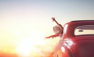Kind im Auto voll Freude auf dem Weg der untergehenden Sonne entgegen