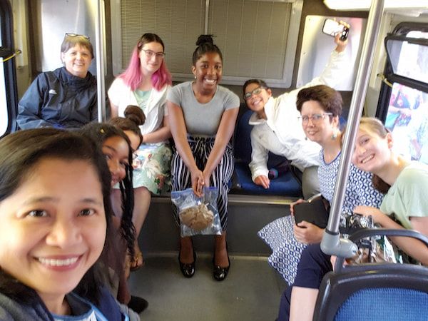 Malana (red hair) and Agnes Iniubong with friends sitting at the back of a bus