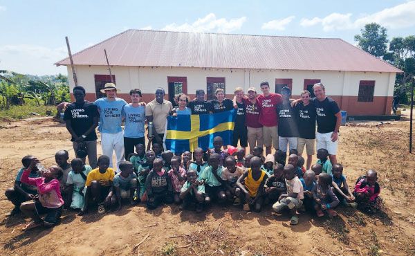 Den färdiga skolbyggnaden med volontärerna och några av skolbarnen utanför.