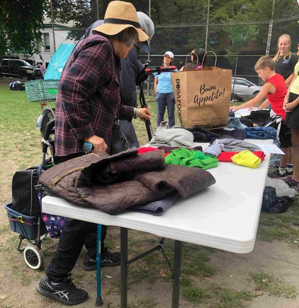 People busy around a table with cloths on.