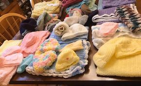 Un bel assortiment de vêtements au crochet, soigneusement disposés sur une table.