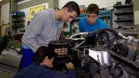 3 jovens consertando máquina