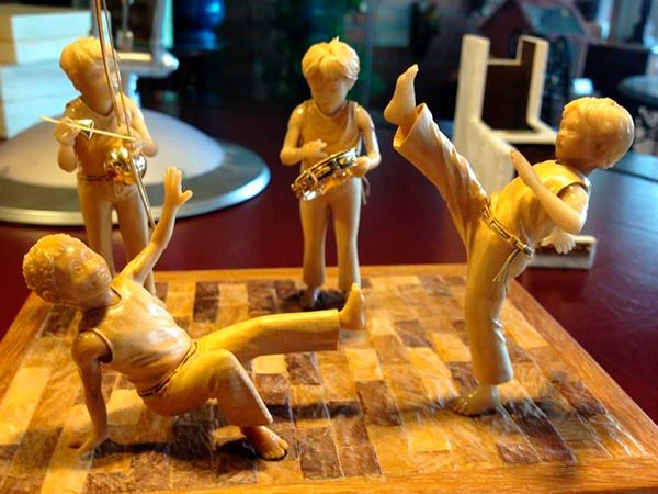 Miniaturas de 4 bonecos jogando capoeira