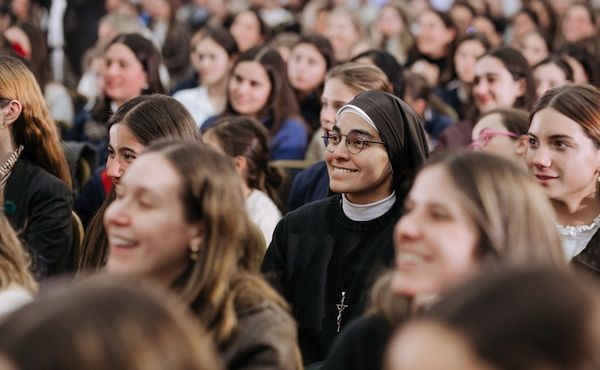 Focus on a young nun smiling amist the crowd