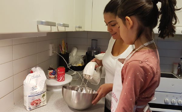 En mor och dotter bakar i köket