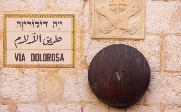 Skylt med text korsväg på hebreiska, arabiska och latin. Femte stationen