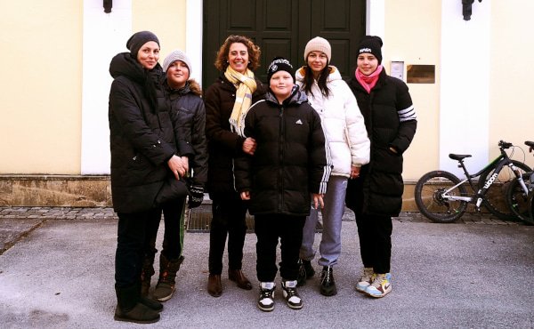 Zwei ukrainische Familien und die Leiterin des Tagungshauses vor dem Eingang