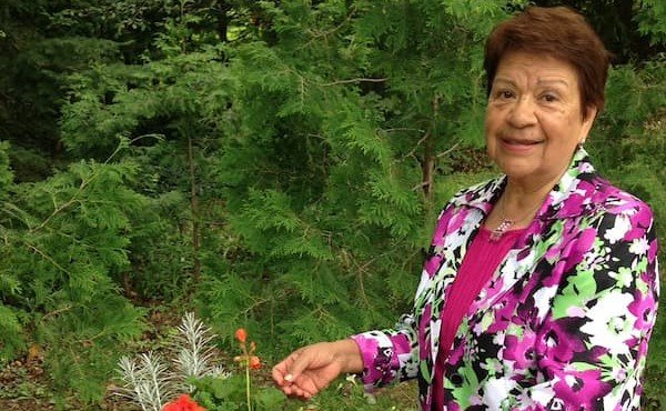 Hery devant des fleurs rouges au jardin.