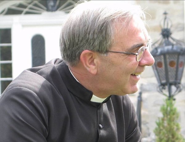L’abbé Blais vue de profil, habillé avec le clergyman et le col romain.