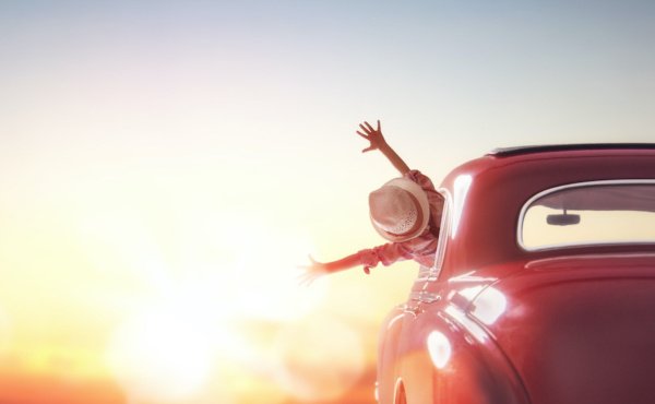 Kind im Auto voll Freude auf dem Weg der untergehenden Sonne entgegen